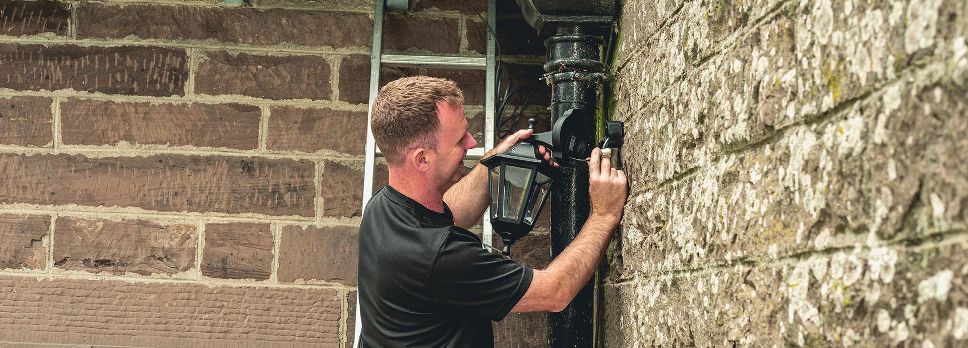 Man fitting light outside